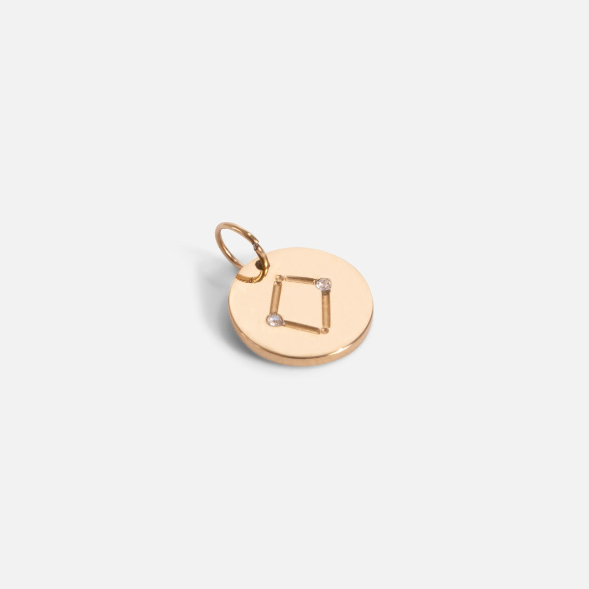 Small golden charm engraved with the zodiac constellation "libra"