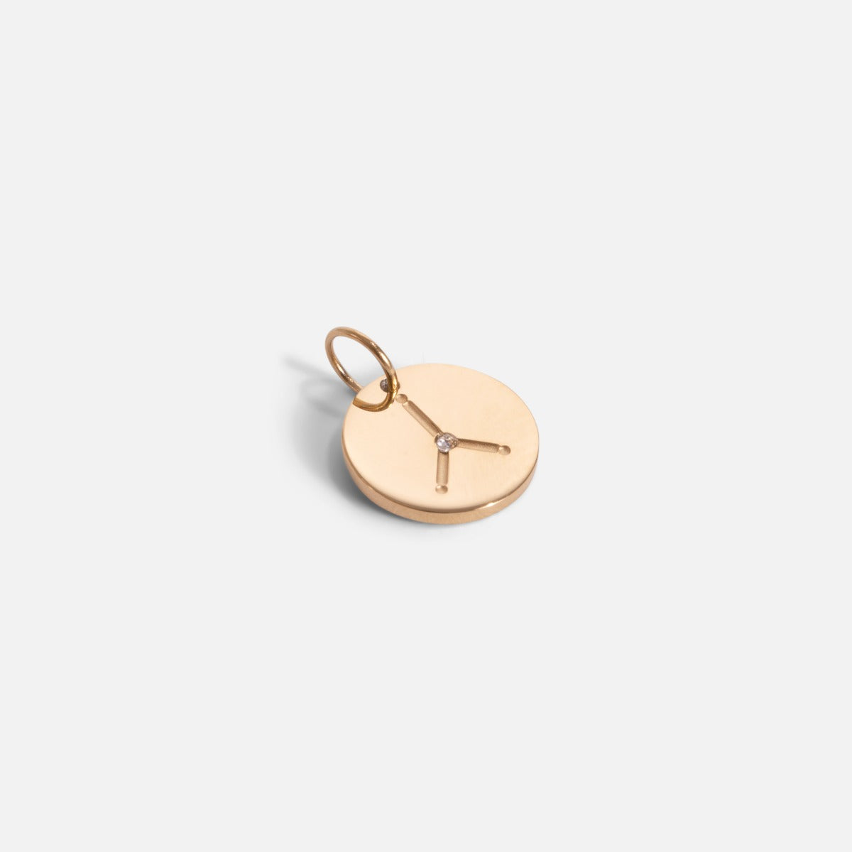 Small golden charm engraved with the zodiac constellation "cancer"
