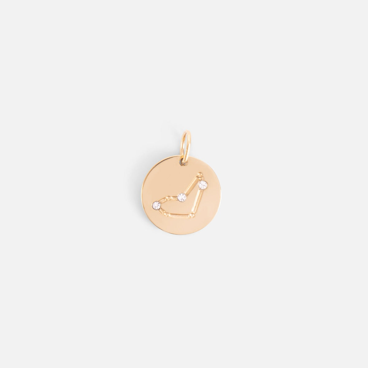 Small golden charm engraved with the zodiac constellation "capricorn"