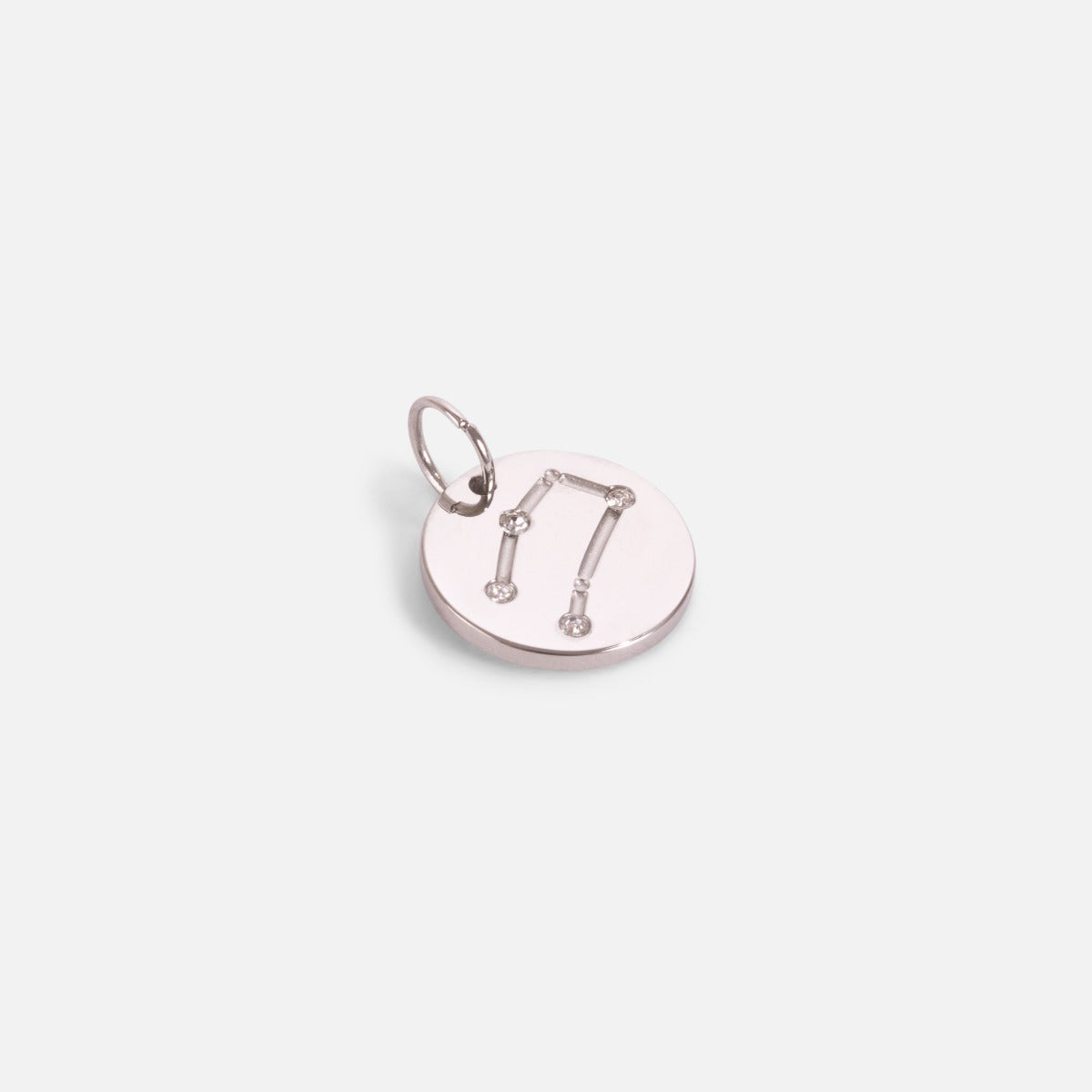 Small silvered charm engraved with the zodiac constellation "gemini"
