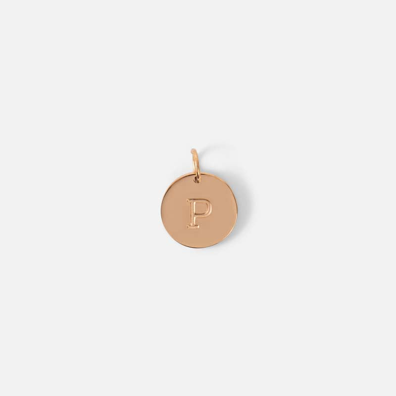 Small symbolic golden charm engraved with the letter of the alphabet "p"