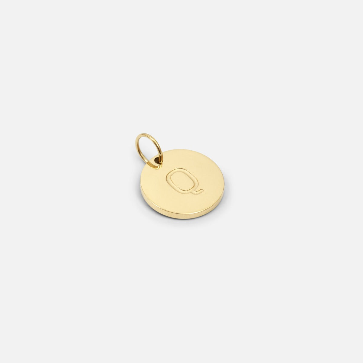 Small symbolic golden charm engraved with the letter of the alphabet "q"