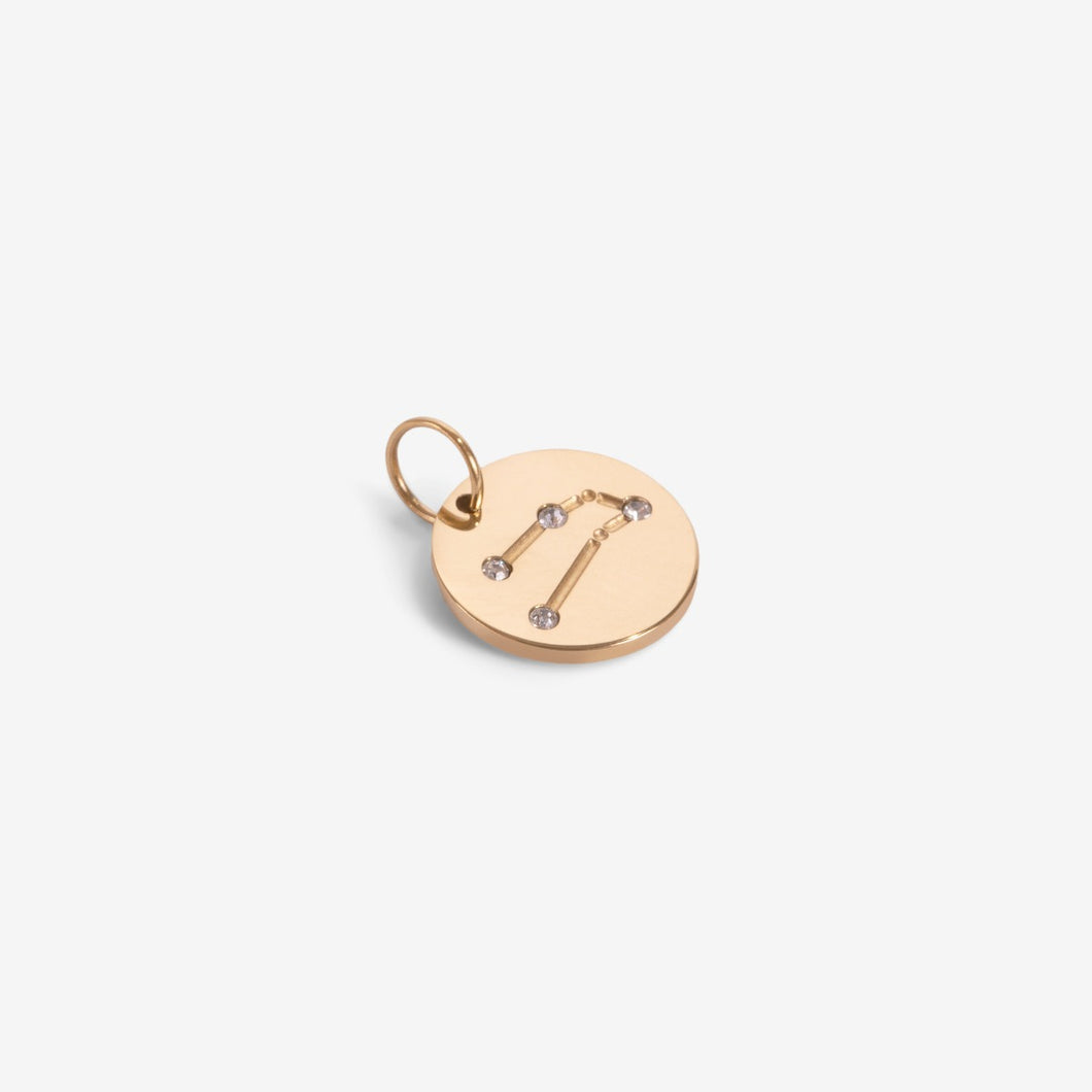 Small golden charm engraved with the zodiac constellation 
