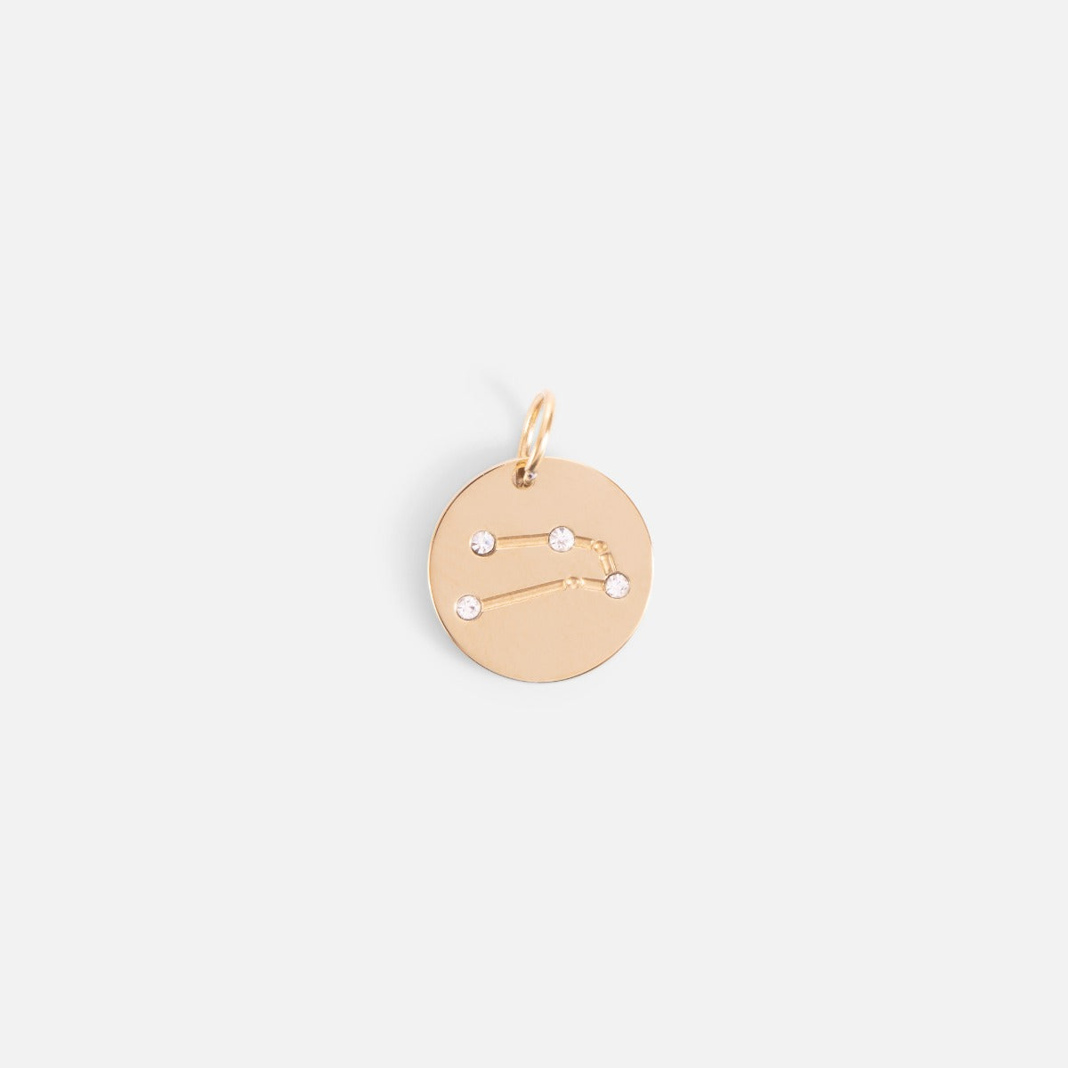 Small golden charm engraved with the zodiac constellation "taurus"