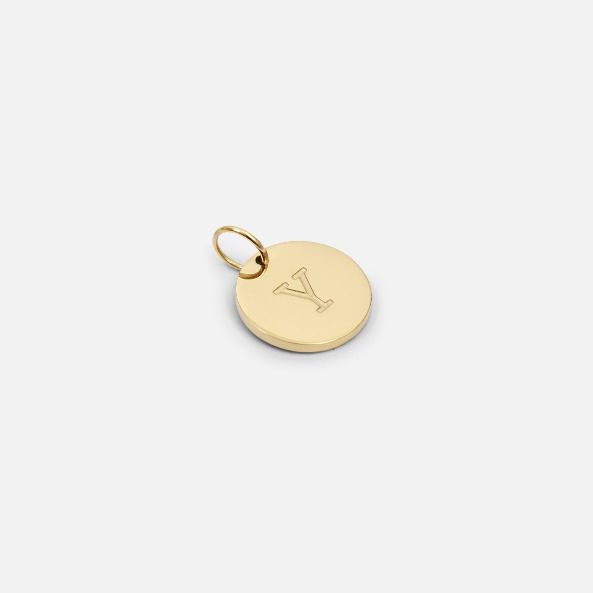 Small symbolic golden charm engraved with the letter of the alphabet "y"