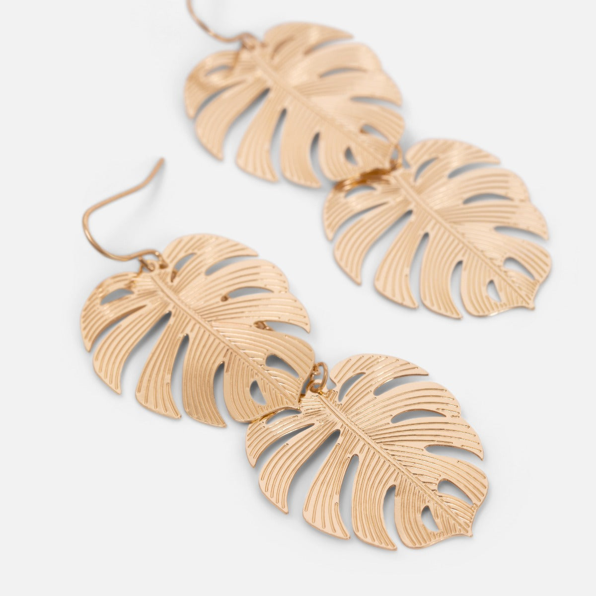 Longues boucles d’oreilles dorées avec motif feuilles de palmier