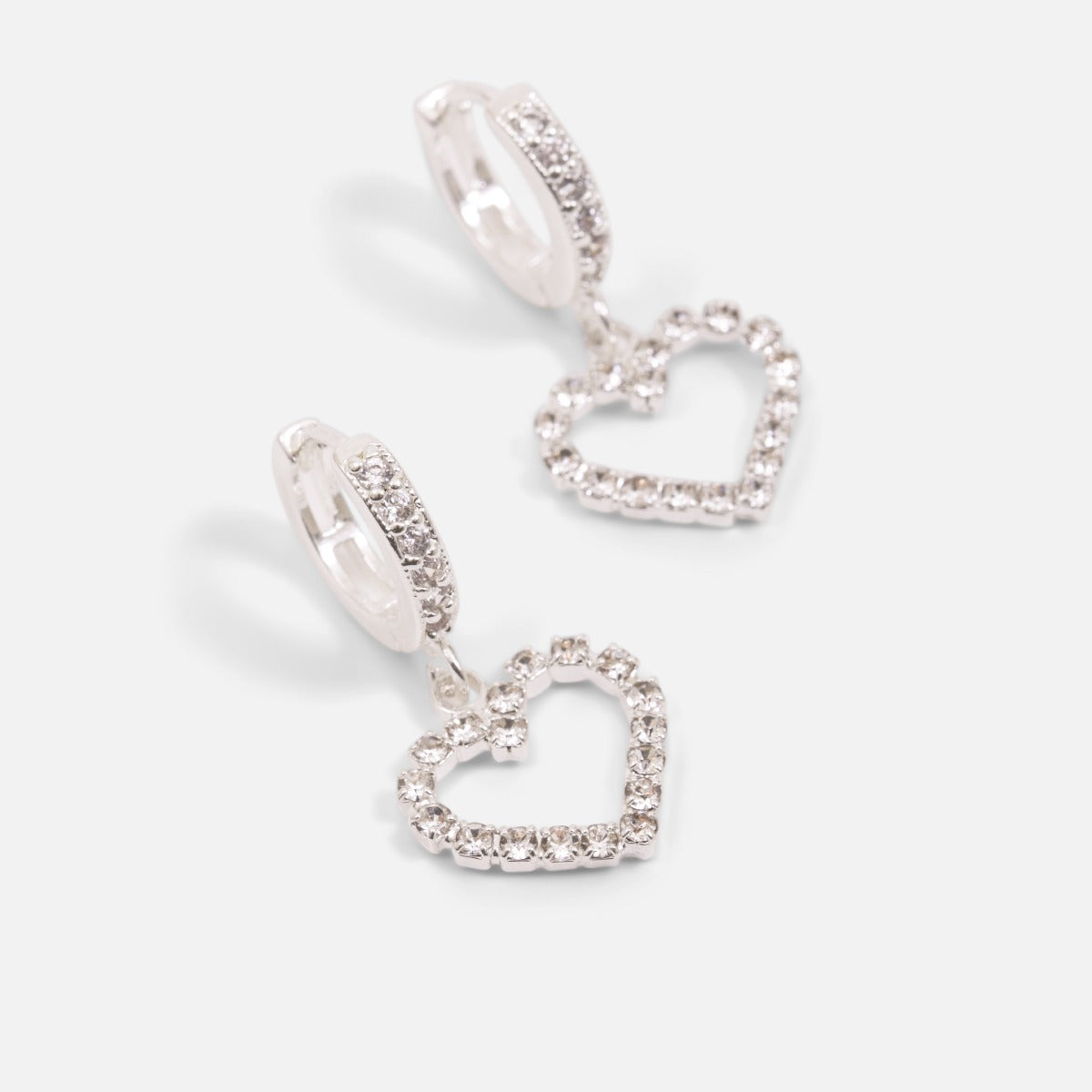 Silvered hoop earrings with sparkling stones and a heart charm